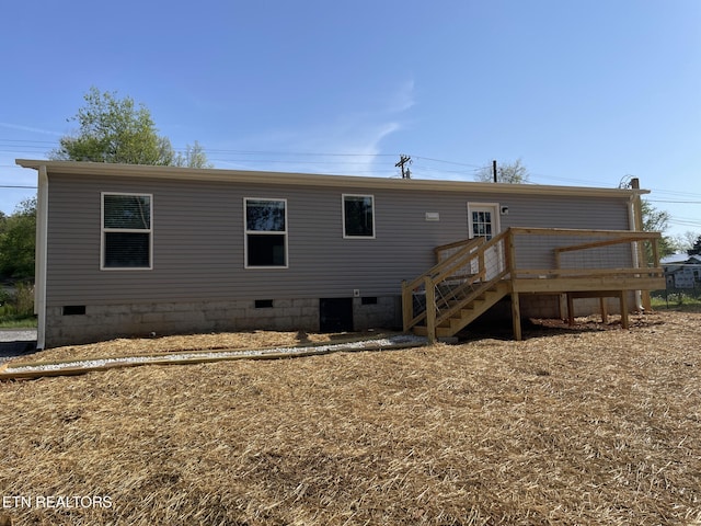 rear view of property with a wooden deck, crawl space, and stairs