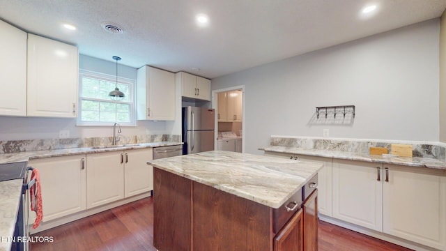 1624 Capitol Blvd, Knoxville, TN 37931 - kitchen featuring appliances with stainless steel finishes, separate washer and dryer, a sink, dark wood finished floors, and light stone countertops