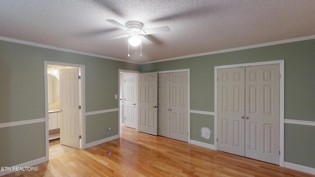 1624 Capitol Blvd, Knoxville, TN 37931 - unfurnished bedroom with two closets, light wood finished floors, crown molding, connected bathroom, and a textured ceiling