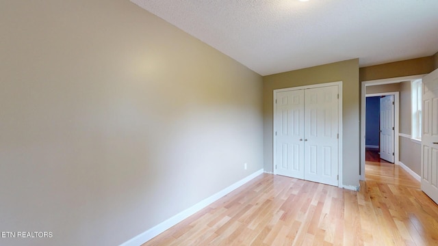 1624 Capitol Blvd, Knoxville, TN 37931 - unfurnished bedroom featuring light wood-type flooring, a closet, baseboards, and a textured ceiling