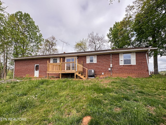 back of house with central AC unit, brick siding, and a deck