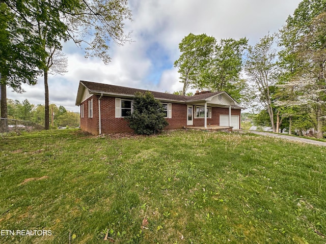ranch-style house featuring brick siding, a front lawn, and a garage