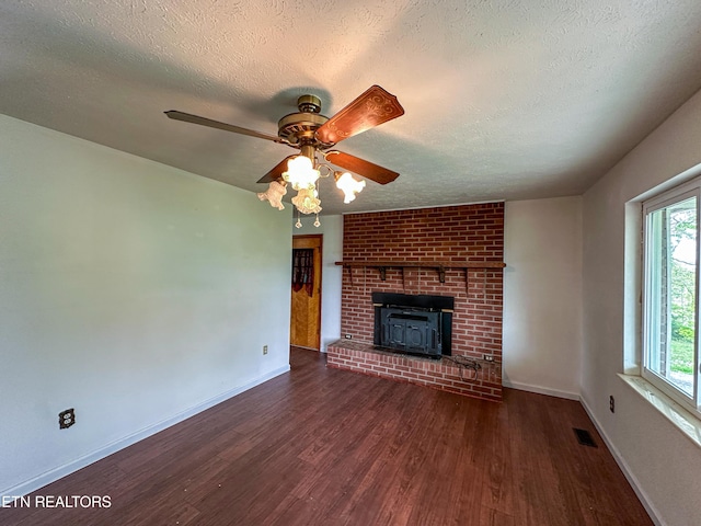 unfurnished living room with wood finished floors, visible vents, a ceiling fan, baseboards, and a textured ceiling