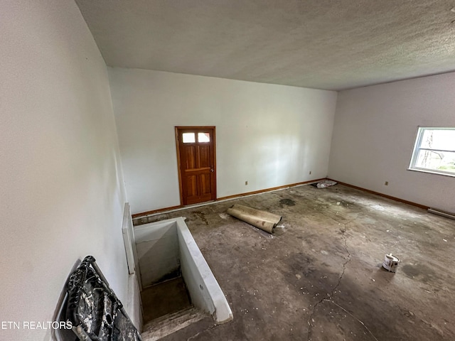 interior space featuring baseboards and a textured ceiling