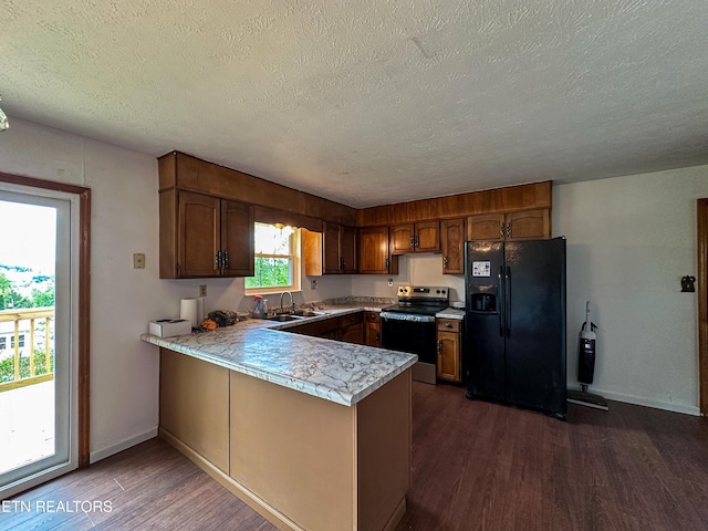 kitchen with black fridge with ice dispenser, stainless steel range with electric stovetop, light countertops, a peninsula, and dark wood-style flooring