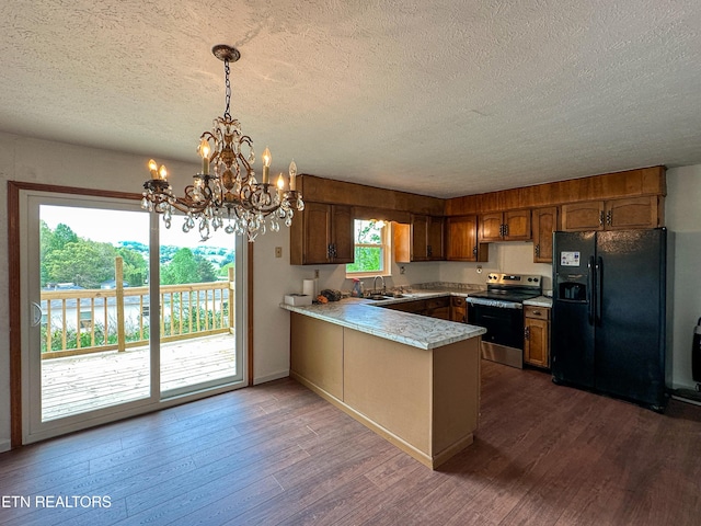 kitchen featuring a peninsula, stainless steel electric range, black fridge, and a textured ceiling