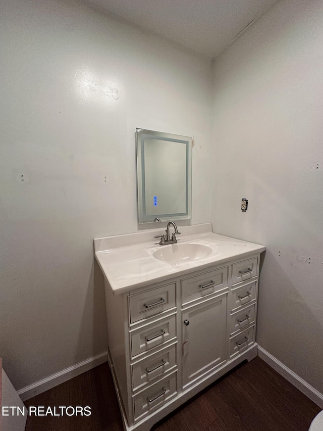 bathroom featuring wood finished floors, baseboards, and vanity