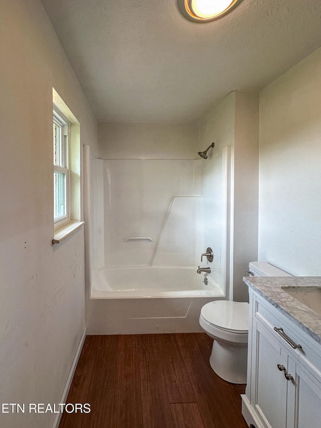 full bath featuring shower / bathing tub combination, wood finished floors, vanity, and toilet