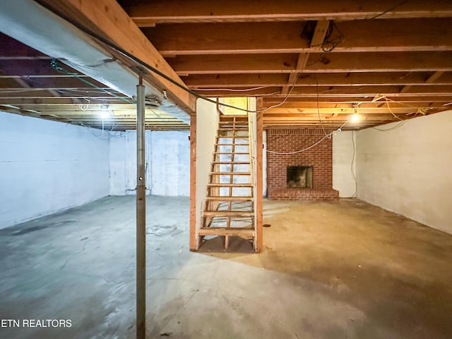 unfinished basement featuring a brick fireplace