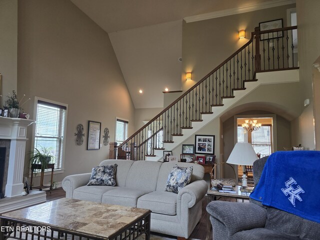 184 Danielle Ct, Harrogate, TN 37752 - living room with a chandelier, a fireplace, wood finished floors, high vaulted ceiling, and stairs