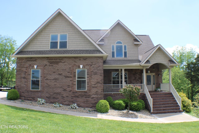 184 Danielle Ct, Harrogate, TN 37752 - craftsman-style home featuring roof with shingles, covered porch, stairway, brick siding, and a front lawn