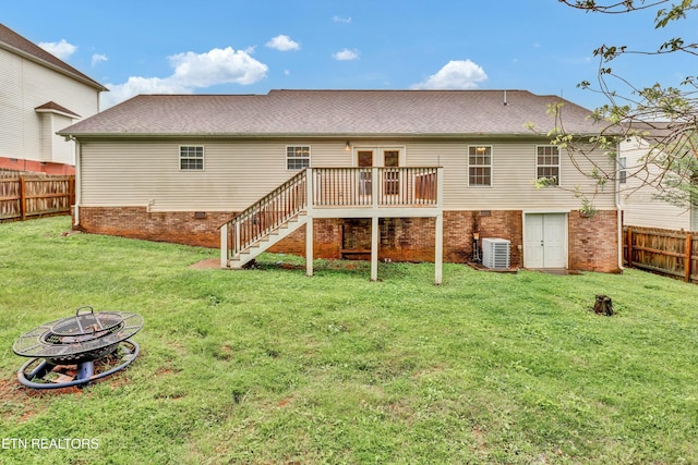 back of property featuring a wooden deck, a fenced backyard, stairs, an outdoor fire pit, and a yard