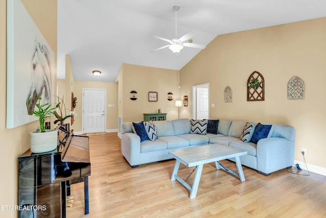 living area with light wood-style floors, baseboards, a ceiling fan, and high vaulted ceiling