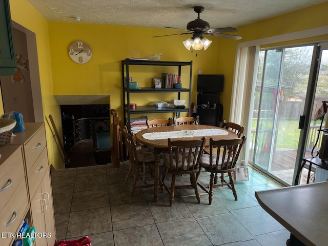 dining area featuring a textured ceiling, a ceiling fan, and light tile patterned floors