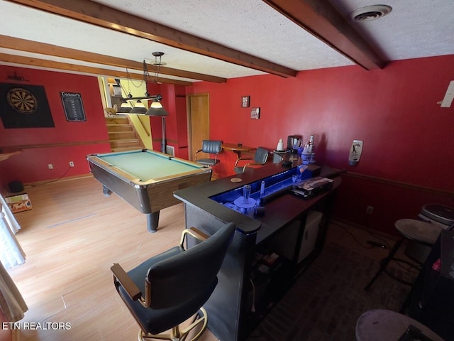 game room featuring wood finished floors, visible vents, beam ceiling, pool table, and a textured ceiling