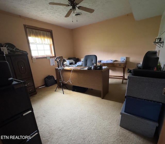 carpeted office with a ceiling fan and a textured ceiling