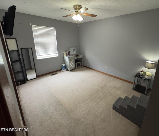 unfurnished bedroom with visible vents, carpet floors, baseboards, a textured ceiling, and ceiling fan