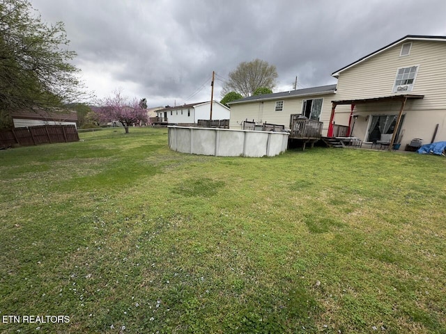 view of yard featuring an outdoor pool and a deck