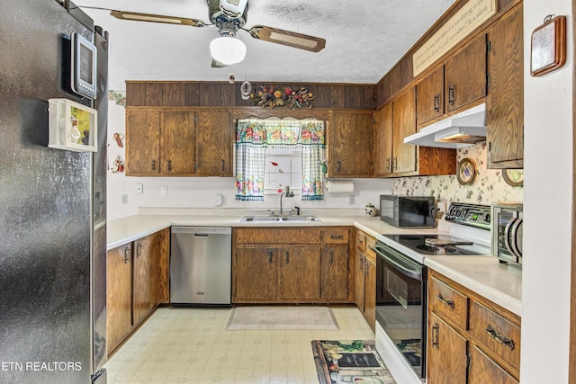 kitchen featuring a sink, light floors, ceiling fan, appliances with stainless steel finishes, and under cabinet range hood