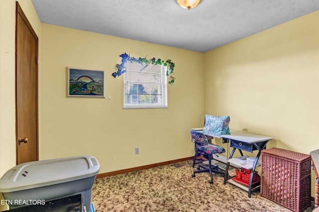 carpeted home office with a textured ceiling and baseboards