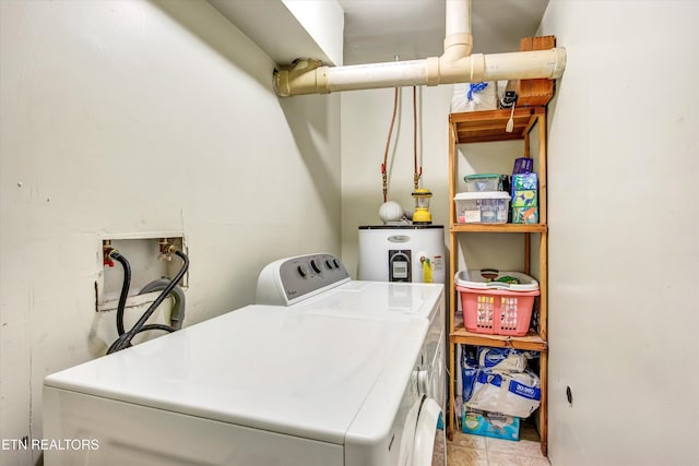 clothes washing area featuring water heater, washing machine and clothes dryer, and laundry area