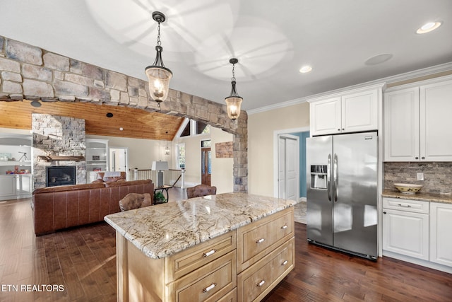 kitchen with light stone countertops, stainless steel refrigerator with ice dispenser, white cabinetry, and dark wood-style flooring