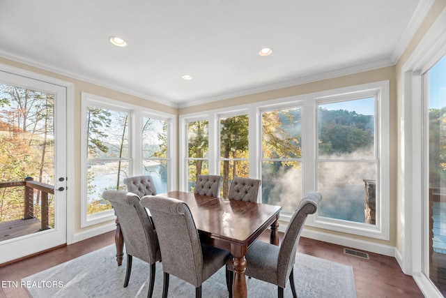 sunroom with crown molding, baseboards, visible vents, and a healthy amount of sunlight
