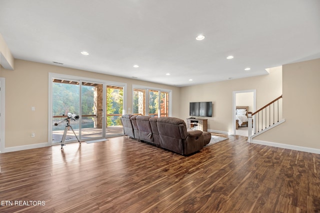 living area featuring baseboards, wood finished floors, recessed lighting, and stairs
