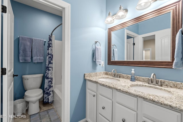 bathroom with tile patterned floors, a sink, double vanity, and toilet