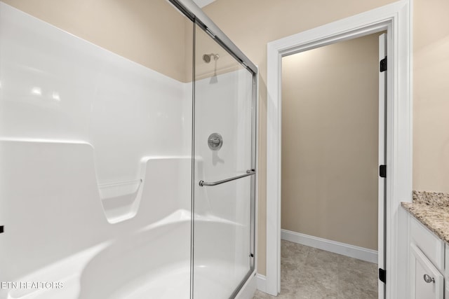 bathroom with baseboards, vanity, and a stall shower