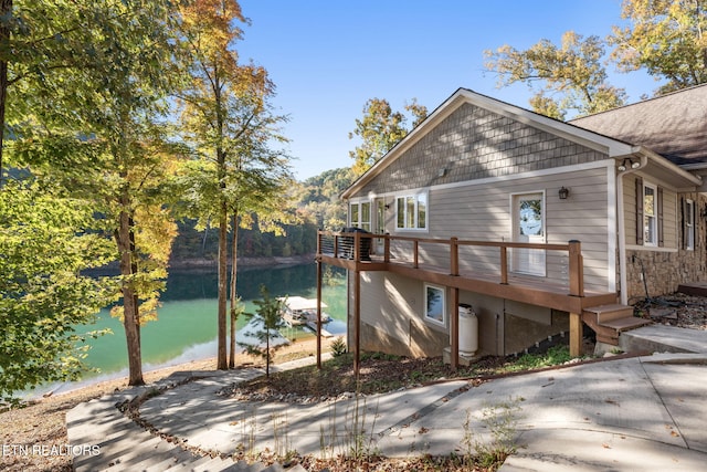 view of property exterior featuring a deck with water view