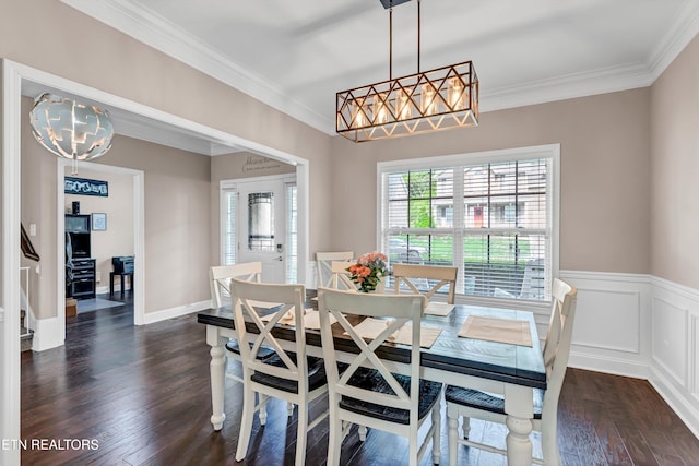 dining space featuring ornamental molding, an inviting chandelier, and dark wood-style flooring