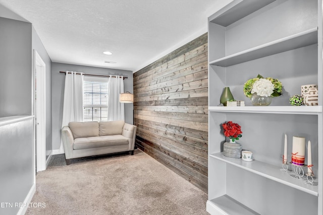 living area featuring recessed lighting, wood walls, carpet flooring, baseboards, and a textured ceiling
