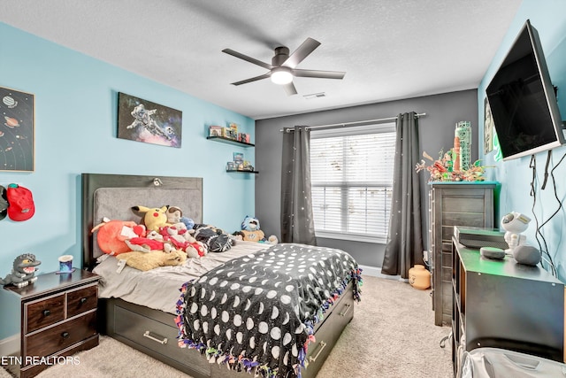 carpeted bedroom featuring a textured ceiling, visible vents, ceiling fan, and baseboards