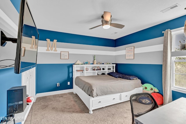carpeted bedroom featuring a ceiling fan, visible vents, and baseboards