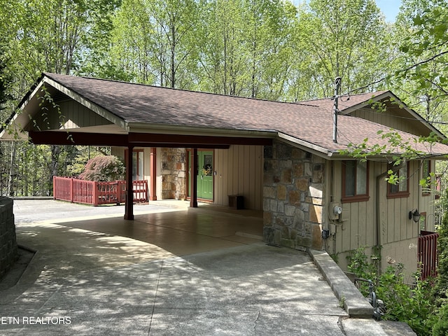 1713 Cardinal Dr, Gatlinburg, TN 37738 - exterior space with roof with shingles, a carport, concrete driveway, and stone siding