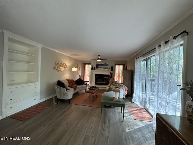 1713 Cardinal Dr, Gatlinburg, TN 37738 - living room featuring wood finished floors, ornamental molding, a fireplace with raised hearth, baseboards, and a ceiling fan