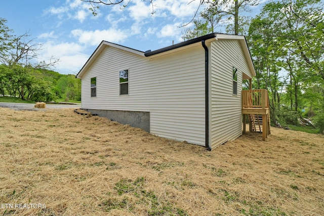 view of side of home featuring a wooden deck and stairway