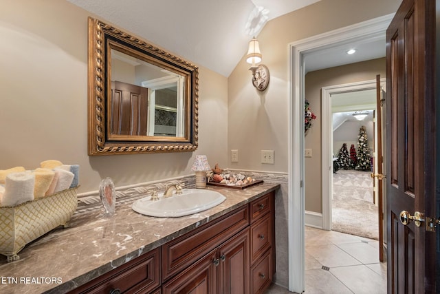 bathroom with tile patterned floors, vanity, and lofted ceiling