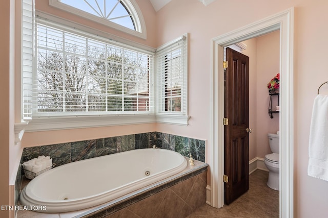 full bathroom featuring tile patterned flooring, toilet, and a tub with jets