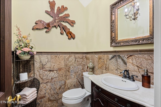 half bathroom featuring toilet, wainscoting, and vanity