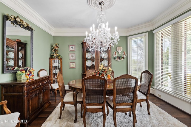 dining area featuring baseboards, an inviting chandelier, ornamental molding, and wood finished floors