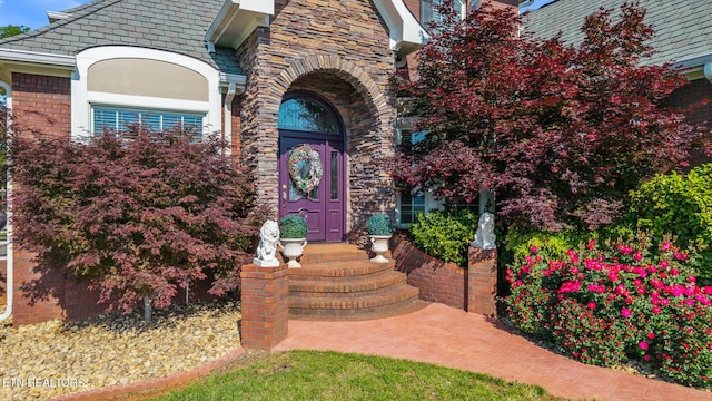 view of exterior entry featuring brick siding