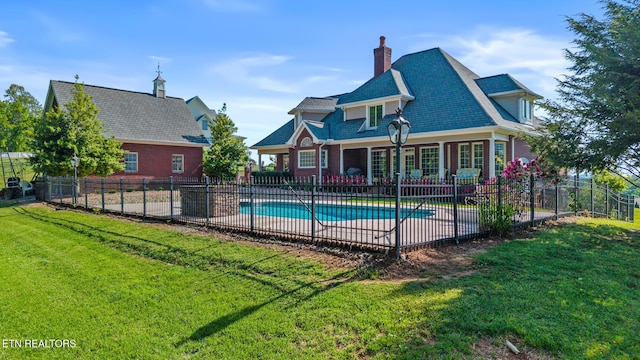 view of swimming pool with a lawn, fence, a fenced in pool, and a patio area