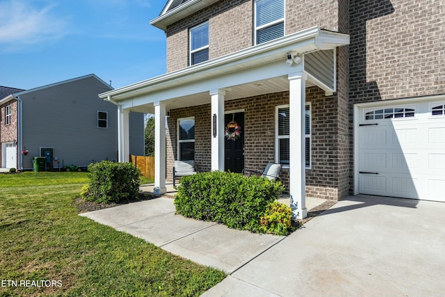 doorway to property featuring a lawn, covered porch, and brick siding