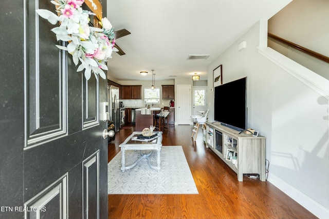 living room with visible vents, dark wood-style floors, and baseboards