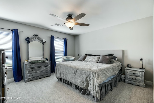 bedroom featuring baseboards, visible vents, ceiling fan, and light colored carpet