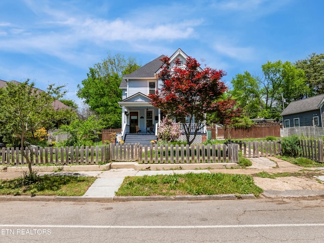 view of front of property featuring a porch and a fenced front yard