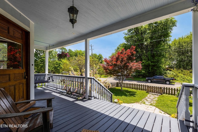 wooden terrace featuring a yard and a porch