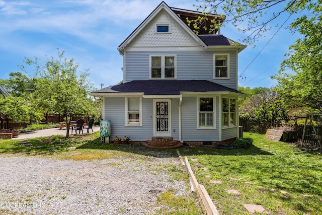 view of front of home featuring a front yard, a shingled roof, a patio area, and fence